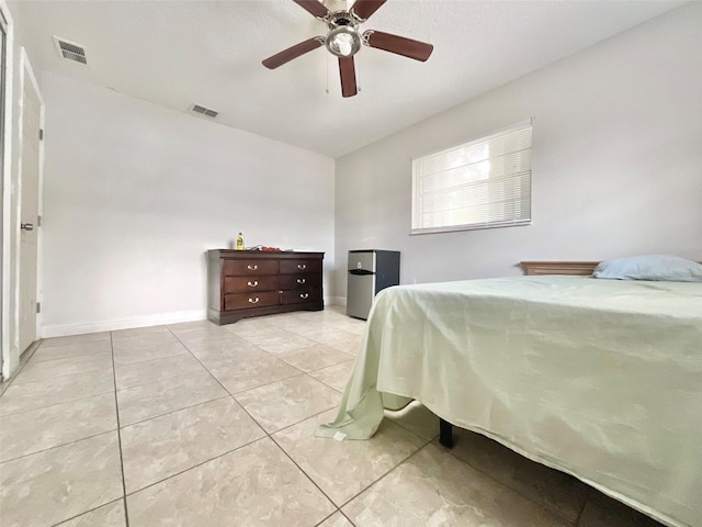 bedroom featuring baseboards, visible vents, a ceiling fan, and light tile patterned flooring