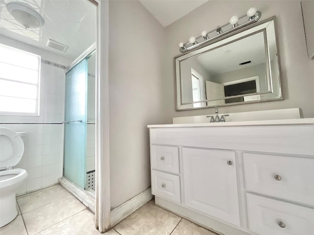 full bath with a stall shower, visible vents, toilet, tile patterned flooring, and vanity