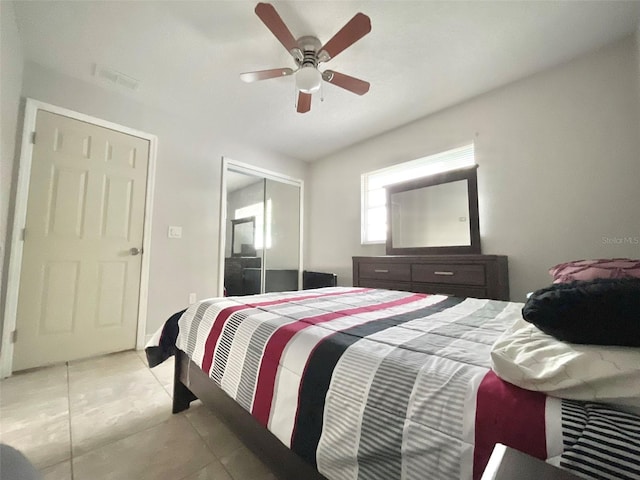 bedroom featuring ceiling fan, a closet, light tile patterned flooring, and visible vents