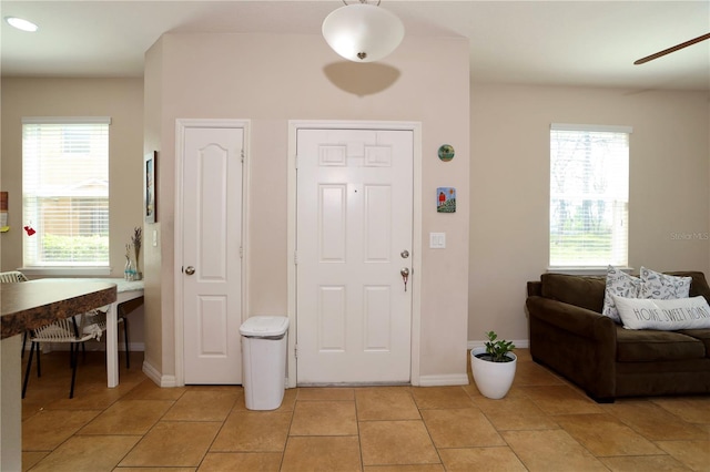 entryway featuring light tile patterned floors and baseboards