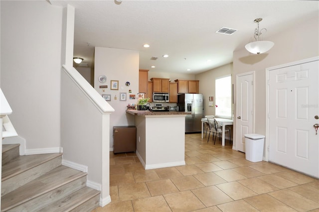 kitchen featuring decorative light fixtures, stainless steel appliances, recessed lighting, visible vents, and a peninsula