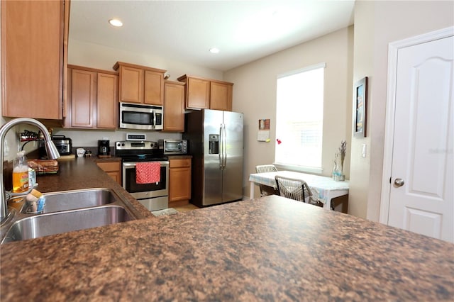 kitchen featuring a toaster, recessed lighting, a sink, appliances with stainless steel finishes, and dark countertops