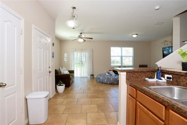 kitchen featuring dark countertops, plenty of natural light, brown cabinets, and open floor plan