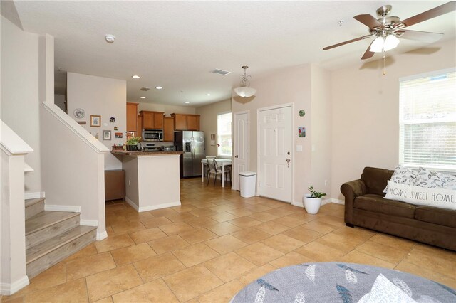 living area with recessed lighting, visible vents, stairway, ceiling fan, and baseboards