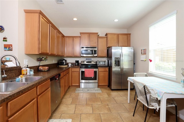 kitchen with a toaster, dark countertops, recessed lighting, appliances with stainless steel finishes, and a sink