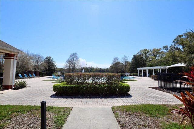 view of community with a pool, a patio area, fence, and a pergola