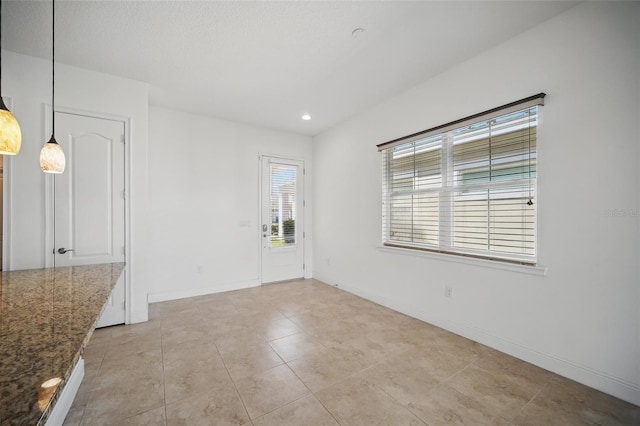 spare room featuring recessed lighting, light tile patterned flooring, and baseboards