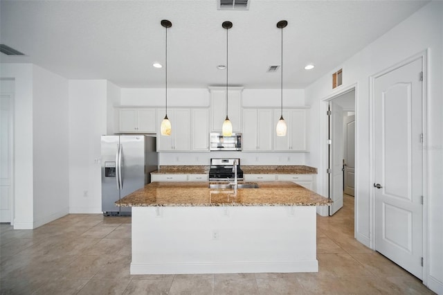 kitchen with appliances with stainless steel finishes, visible vents, light stone counters, and white cabinetry