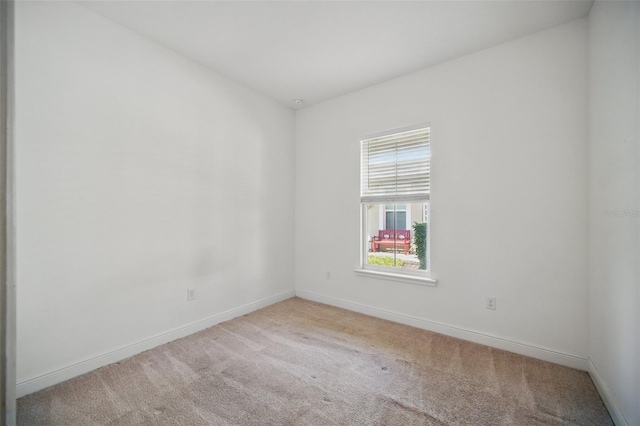 unfurnished room featuring carpet and baseboards