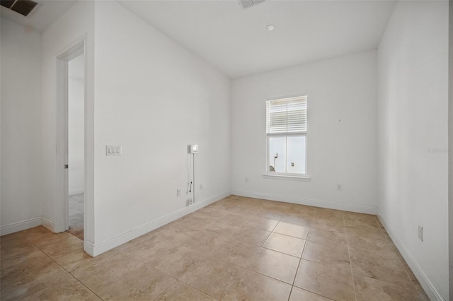 empty room with light tile patterned floors, baseboards, and visible vents