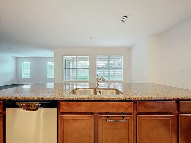 kitchen featuring light stone counters, brown cabinets, visible vents, a sink, and dishwasher