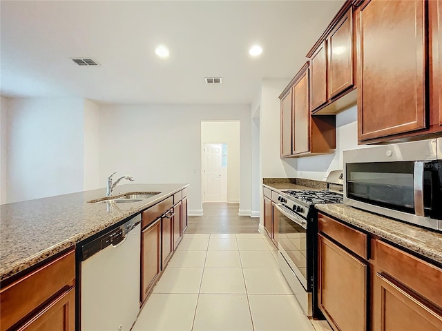 kitchen featuring light tile patterned floors, appliances with stainless steel finishes, a sink, and visible vents