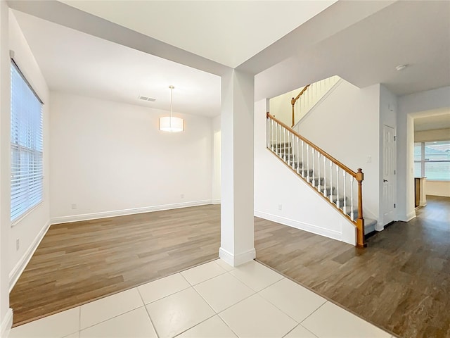 interior space featuring stairway, wood finished floors, visible vents, and baseboards