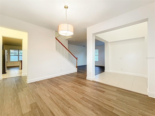 spare room with stairway, wood finished floors, and baseboards