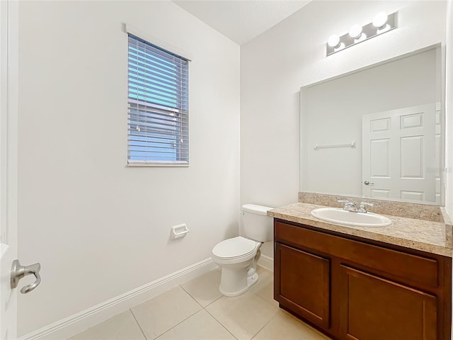 half bath featuring toilet, vanity, baseboards, and tile patterned floors