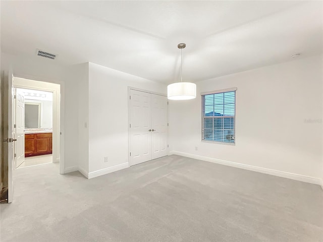 interior space with baseboards, visible vents, and light colored carpet