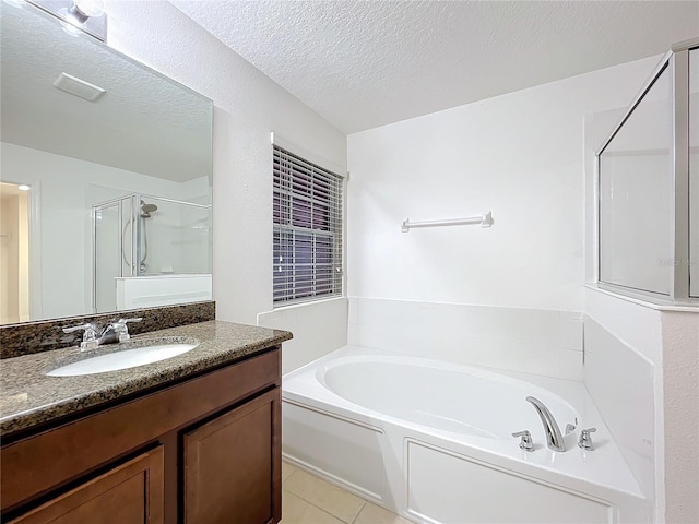 full bath with a bath, a shower stall, a textured ceiling, and vanity