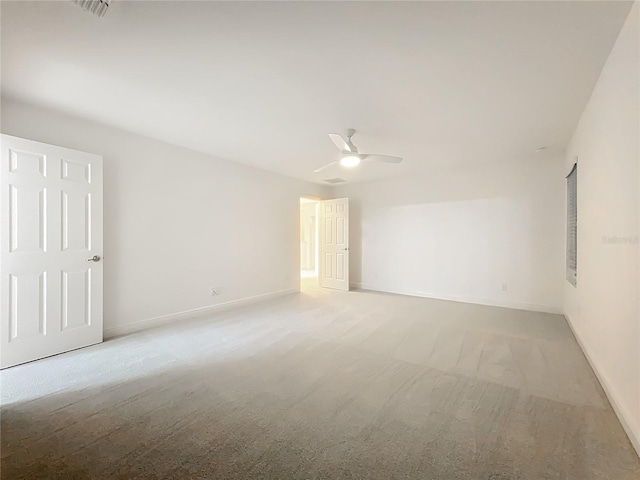 carpeted spare room with baseboards and a ceiling fan