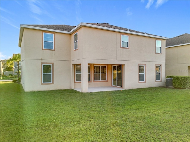 rear view of property with a patio area, a yard, and stucco siding