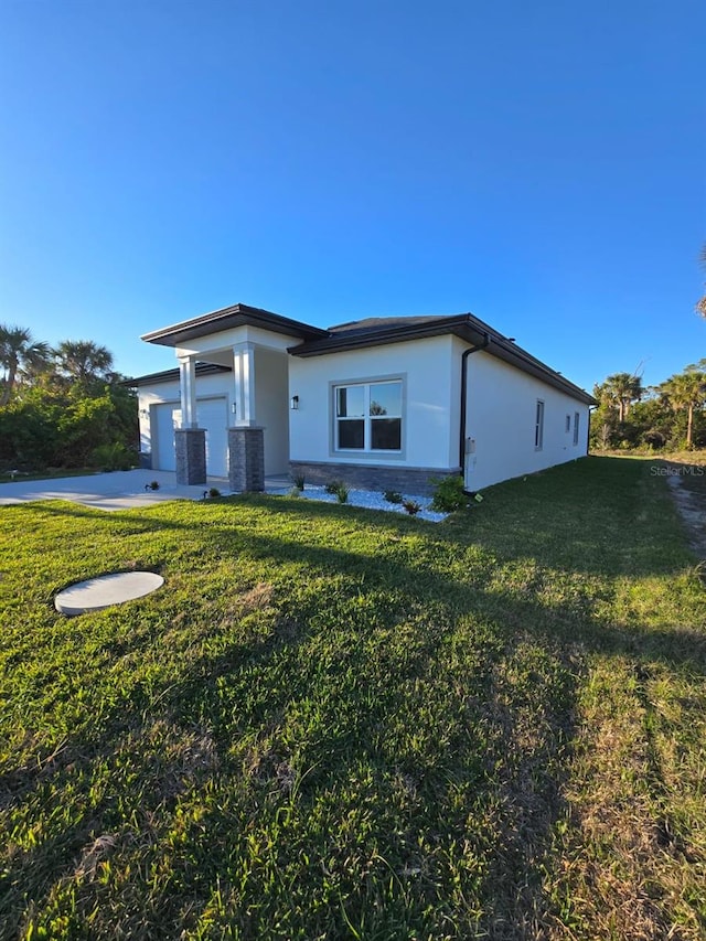 view of front of home with a front lawn, central air condition unit, an attached garage, and stucco siding