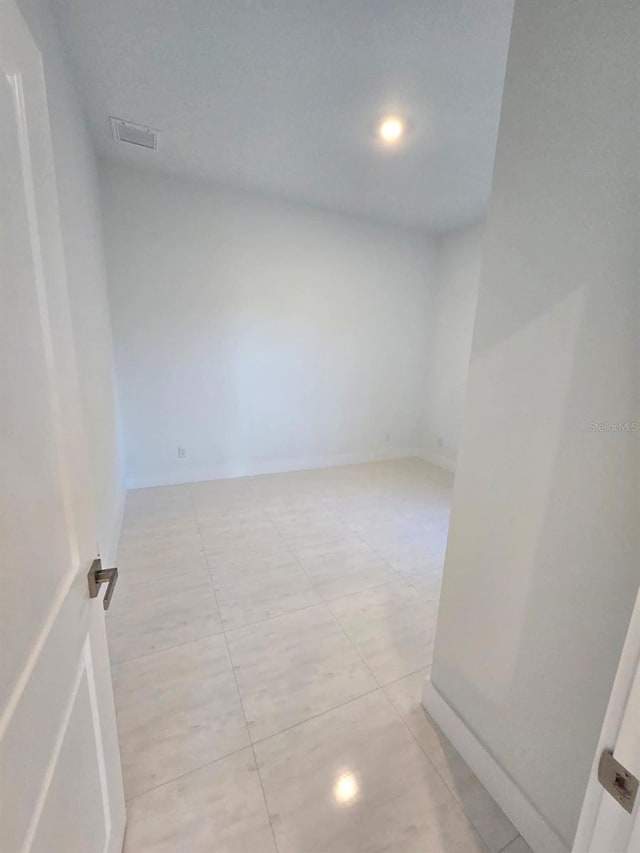 unfurnished room featuring baseboards and light tile patterned flooring