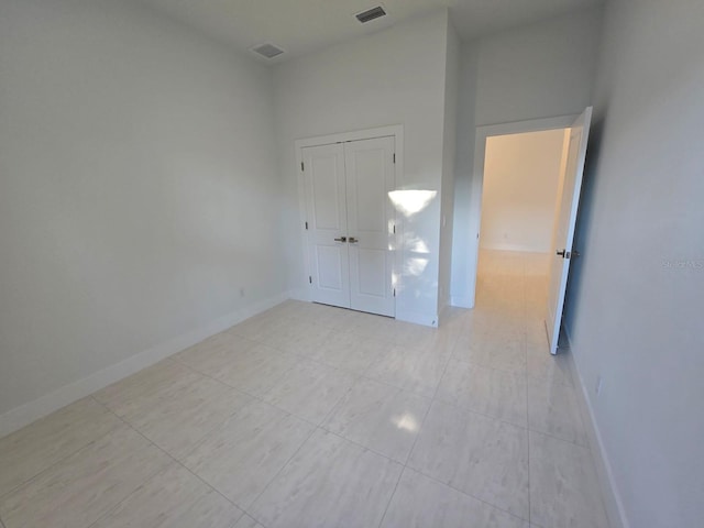 unfurnished bedroom with visible vents, baseboards, and a closet