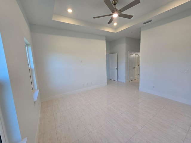 spare room with visible vents, baseboards, ceiling fan, recessed lighting, and a raised ceiling