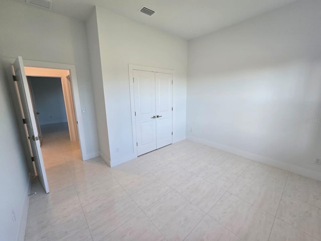 unfurnished bedroom featuring a closet, visible vents, and baseboards