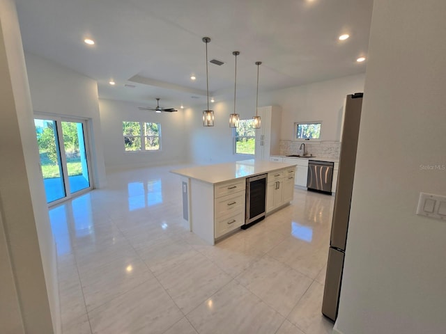 kitchen featuring wine cooler, open floor plan, light countertops, stainless steel appliances, and white cabinetry