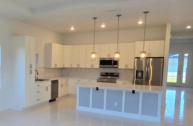 kitchen featuring white cabinets, appliances with stainless steel finishes, a center island, and a sink