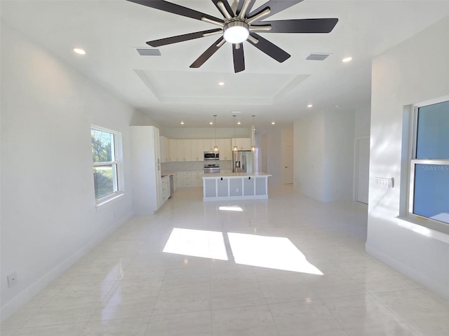 unfurnished living room with visible vents, recessed lighting, and a raised ceiling