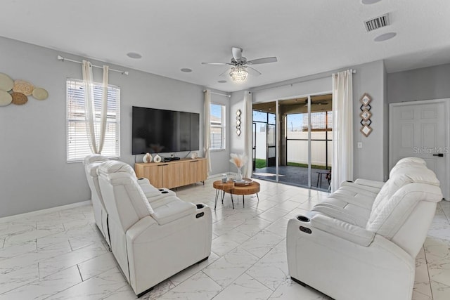 living area featuring marble finish floor, baseboards, visible vents, and a ceiling fan