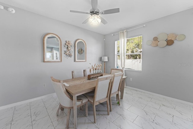 dining area with marble finish floor, ceiling fan, and baseboards