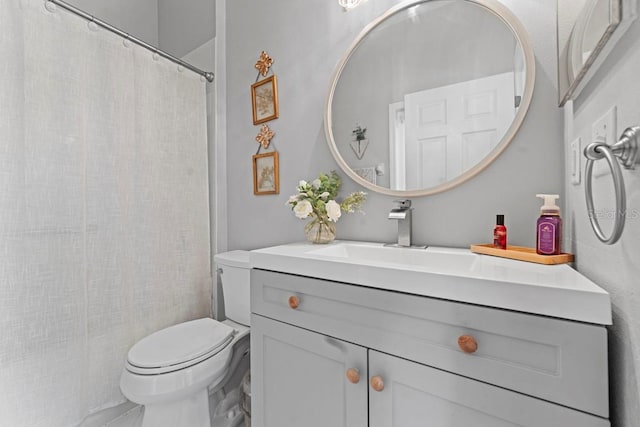 bathroom with curtained shower, vanity, and toilet