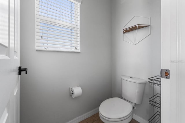 bathroom with tile patterned flooring, baseboards, and toilet