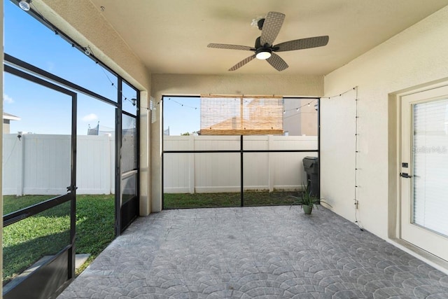 unfurnished sunroom featuring plenty of natural light and ceiling fan