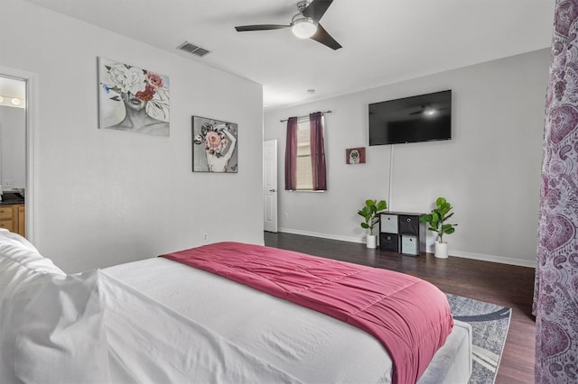 bedroom with visible vents, ceiling fan, baseboards, wood finished floors, and ensuite bath