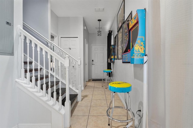 entryway featuring stairs, light tile patterned floors, baseboards, and visible vents