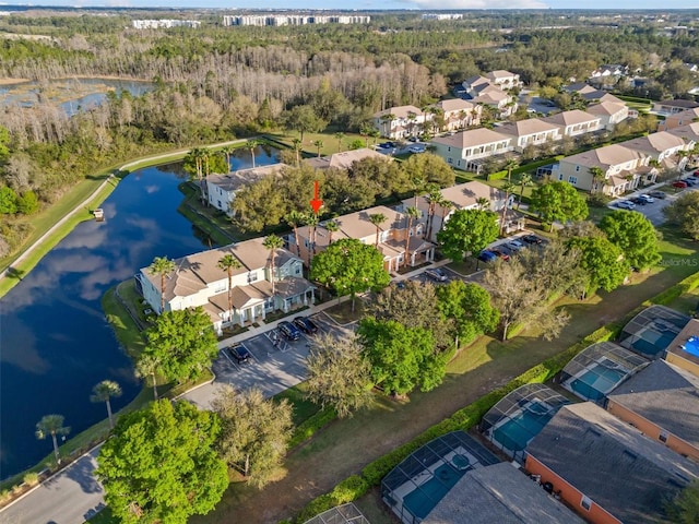 drone / aerial view with a forest view, a residential view, and a water view