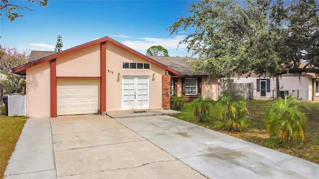 view of front of house with concrete driveway, fence, an attached garage, and stucco siding