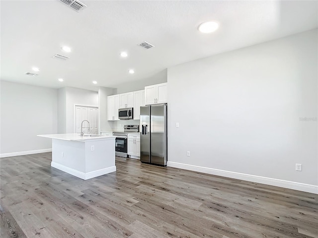 kitchen with stainless steel appliances, a sink, visible vents, and baseboards