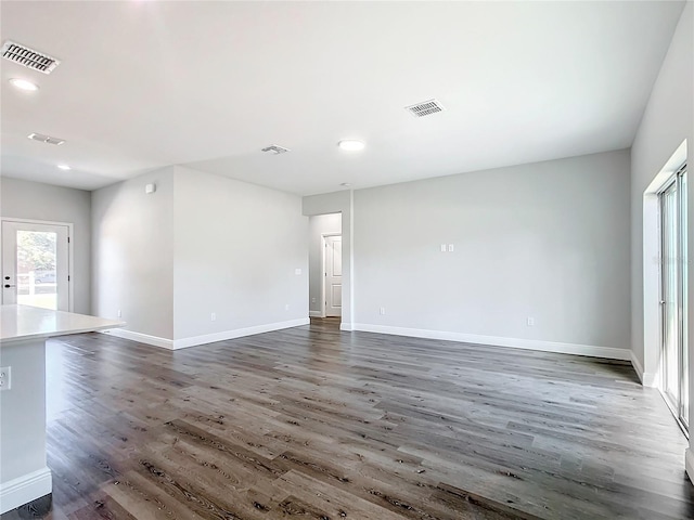 unfurnished room with recessed lighting, wood finished floors, visible vents, and baseboards