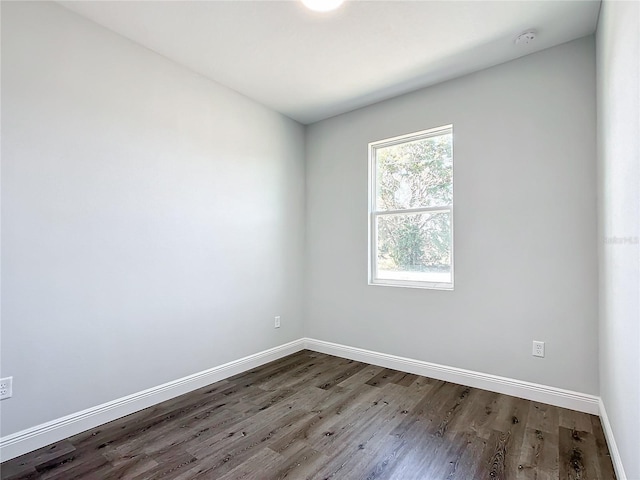 unfurnished room featuring baseboards and wood finished floors