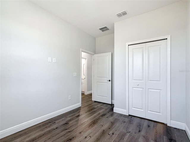 unfurnished bedroom featuring baseboards, visible vents, and dark wood finished floors