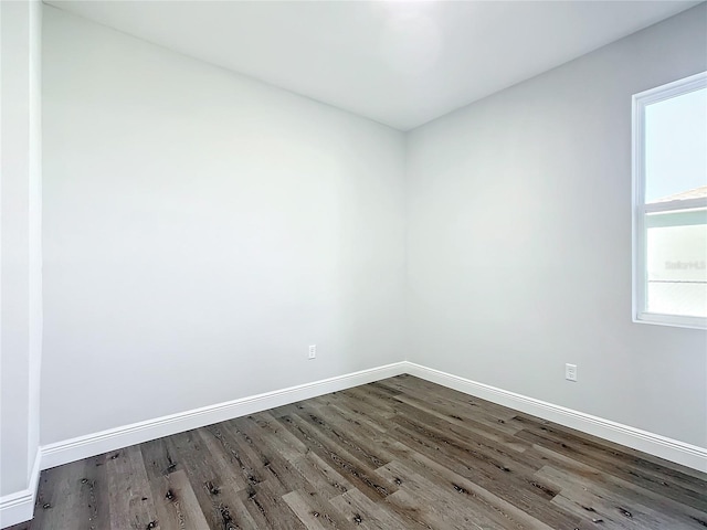 spare room featuring baseboards and wood finished floors