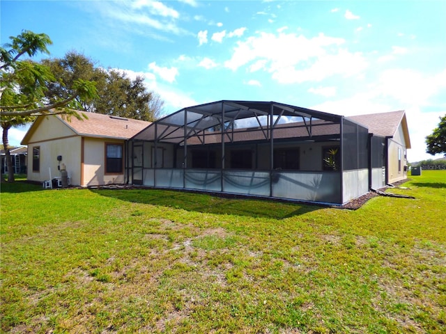 back of house featuring glass enclosure, stucco siding, and a yard