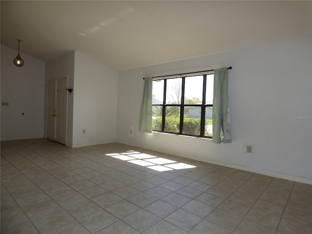 spare room with vaulted ceiling and baseboards