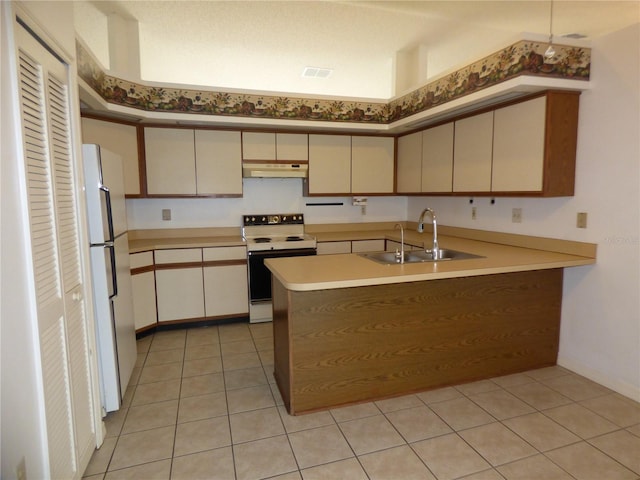 kitchen with freestanding refrigerator, a sink, a peninsula, range with electric cooktop, and under cabinet range hood