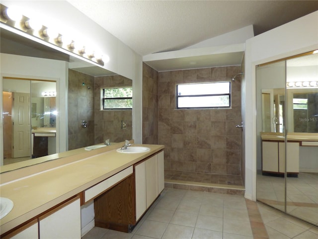 full bathroom with a tile shower, vanity, and tile patterned floors