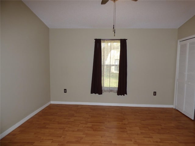 unfurnished room featuring light wood finished floors, baseboards, and a ceiling fan